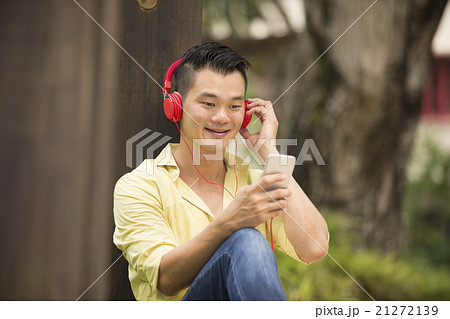 Casual Asian man relaxing outdoors. Casual Asian man relaxing outdoors. 21272139