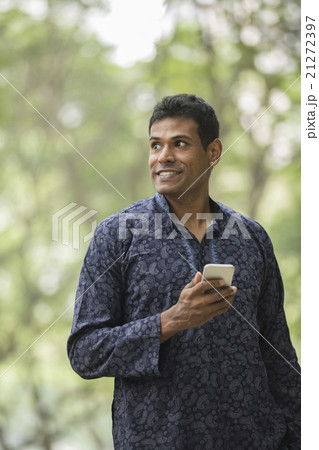 Indian man wearing a kurta and using smart phone. Indian man wearing a kurta and using smart phone. 21272397