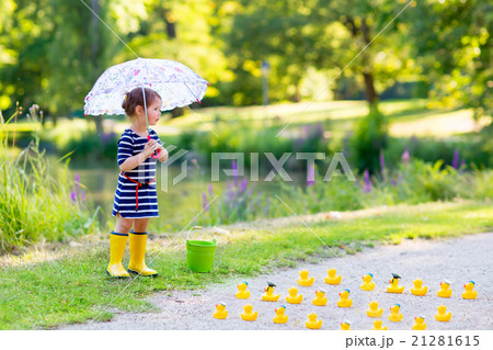 Little girl playing in forest and wearing boots 21281615