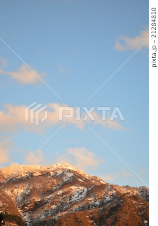 夕焼けに染まる初春の雪山 21284810