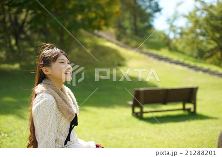 公園のベンチに座りそよ風を感じリラックス癒され清々しい気持ちになるロングヘアーの若い女性 公園のベンチに座りそよ風を感じリラックス癒され清々しい気持ちになるロングヘアーの若い女性 21288201