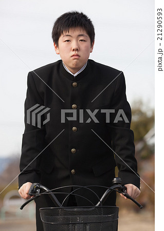 学生服を着て自転車通学をする男子中学生の写真素材