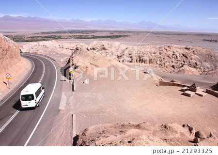 南米チリ、アンデスの麓に広がるアタカマ砂漠にある月の谷の奇岩の中を走る幹線道路とアンデスの山並み 21293325