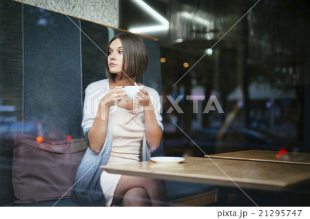 Beautiful woman drinking coffee in city cafe 21295747