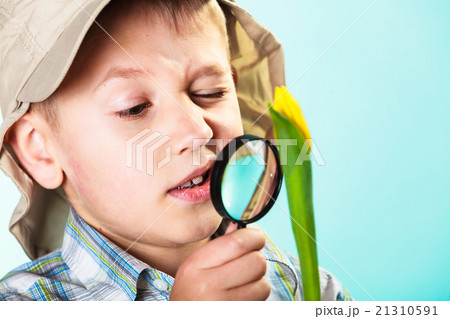 Child looking through a magnifying glass 21310591