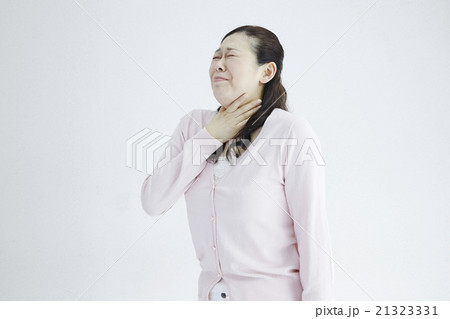 40代女性白バック 喉が痛い 息が苦しい ポーズの写真素材