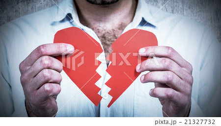 Composite image of sad man holding heart halves Composite image of sad man holding heart halves 21327732