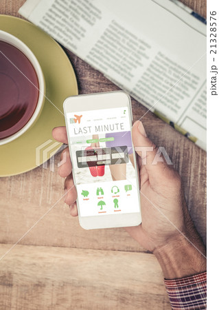 Composite image of man using smart phone by coffee and newspaper Composite image of man using smart phone by coffee and newspaper 21328576
