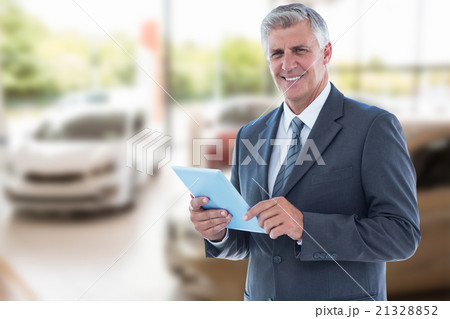 Composite image of smiling businessman using his tablet 21328852