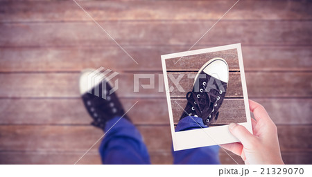 Composite image of hand holding polaroid picture Composite image of hand holding polaroid picture 21329070