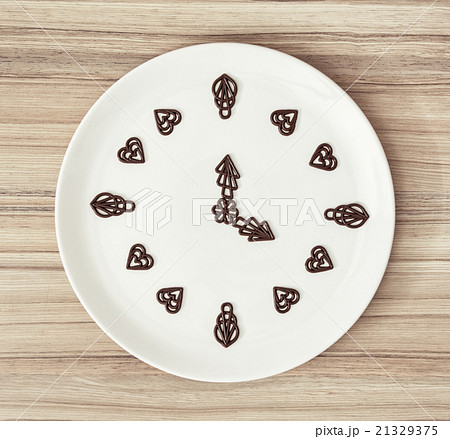 Dark chocolate garnishes in the shape of the clock Dark chocolate garnishes in the shape of the clock 21329375