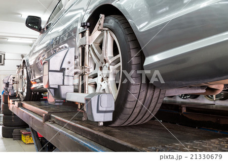 Tire clamped with aligner undergoing wheel align 21330679