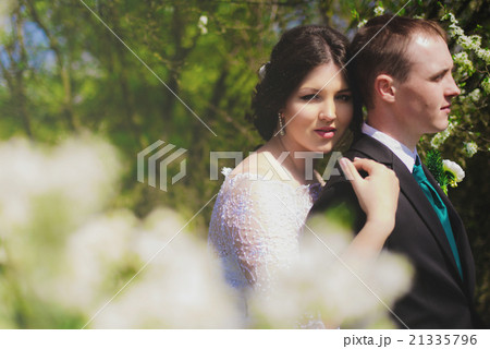 Young bride and groom in a lush garden Young bride and groom in a lush garden 21335796