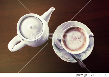 Cup of coffee with hot tea pot on a dark wooden 21335993