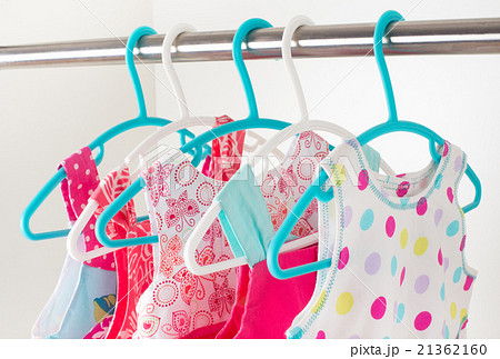 row of little girl dresses hanging on coat hanger 21362160
