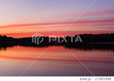 Serene view of calm lake and tree silhouettes 21365988