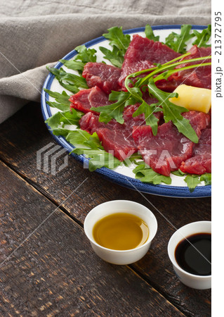 Carpaccio on the white plate on the wooden table 21372795