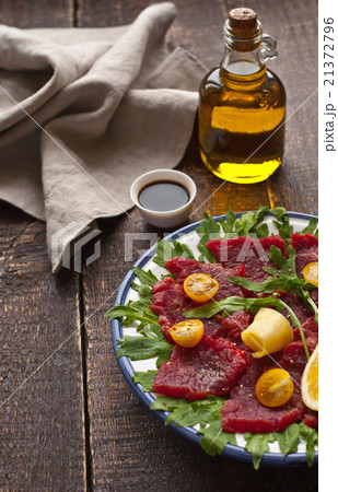 Carpaccio on the white plate on the wooden table 21372796