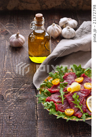Carpaccio on the white plate on the wooden table 21372798
