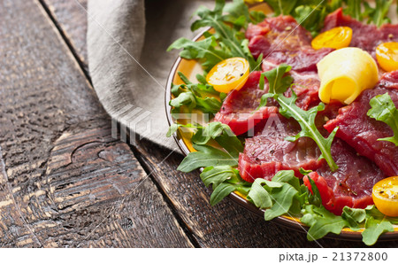 Carpaccio on the white plate on the wooden table 21372800