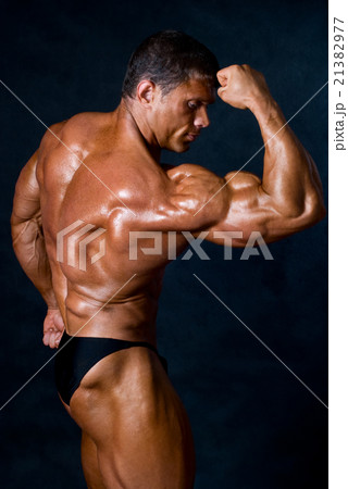 Young athletic man showing his muscles Young athletic man showing his muscles 21382977