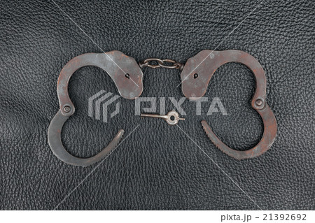 Steel handcuffs lying on the natural leather Steel handcuffs lying on the natural leather 21392692