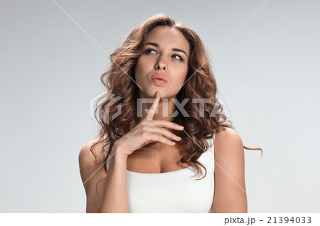 The happy thoughtful woman on gray background The happy thoughtful woman on gray background 21394033