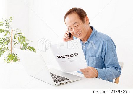 パソコンの使い方を問い合わせるシニア男性 21398059