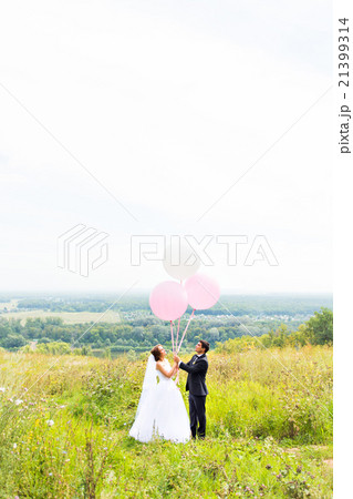groom and bride with balloons on green field groom and bride with balloons on green field 21399314