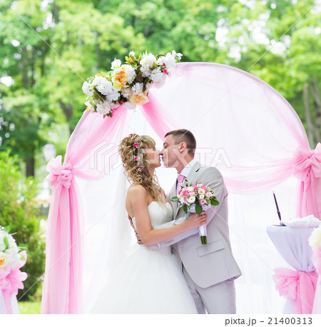 Happy newlywed romantic couple kissing at wedding Happy newlywed romantic couple kissing at wedding 21400313