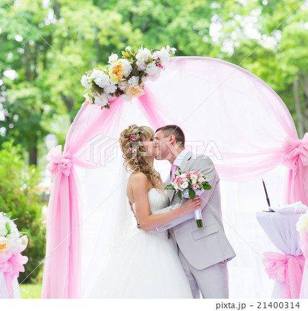 Happy newlywed romantic couple kissing at wedding Happy newlywed romantic couple kissing at wedding 21400314
