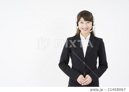 オペレーター ヘッドセットのマイクを付優しく微笑むスーツを着た若く可愛いサポートセンターの女性の写真素材