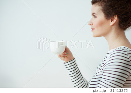 Beautiful brunette girl is enjoying hot drink Beautiful brunette girl is enjoying hot drink 21413275