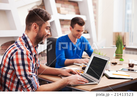 Attractive young workers are using a notebook 21413523