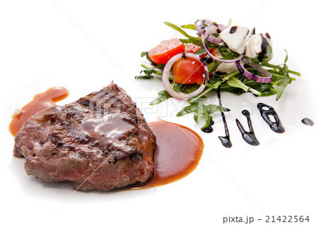 Juicy grilled steak served with a greek salad. 21422564