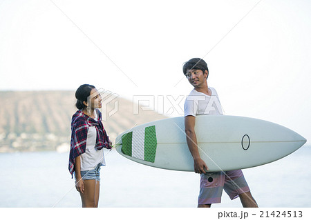 海沿いを歩くカップルの写真素材