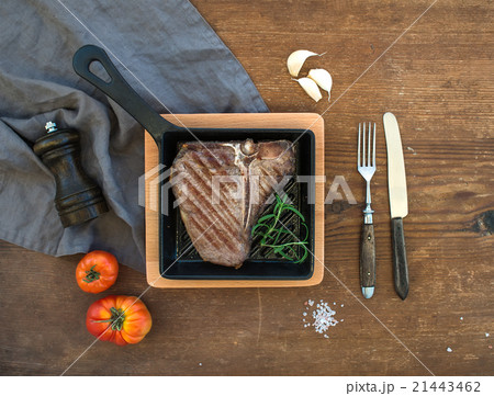 Cooked meat t-bone steak with garlic cloves 21443462