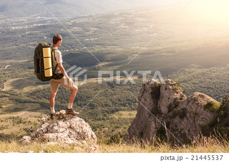 Backpacker on rock and looking at the big valley Backpacker on rock and looking at the big valley 21445537