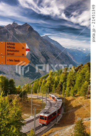 Signpost and Zermatt train in Swiss Alps 21451349