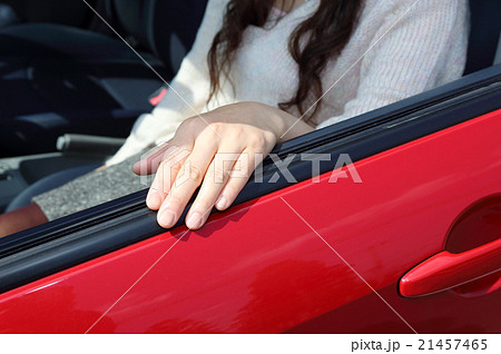 車のドアに手をかける女性の写真素材