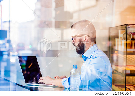 Hipster manager in cafe, working on laptop by Hipster manager in cafe, working on laptop by 21460954