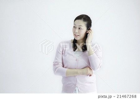 自然光白バック40代女性ミドルエイジ　スマホ／携帯電話喜びのチュエーションの対応とジェスチャー 21467268