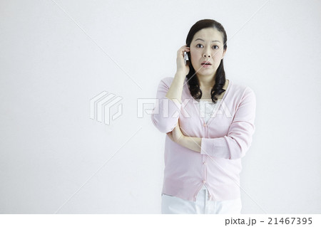 自然光白バック40代女性ミドルエイジ　スマホ／携帯電話いろんなシチュエーションの対応とジェスチャー 21467395