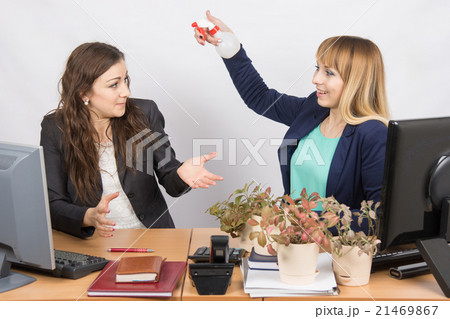 Office employee-grower sprinkles water from pulivizatora on irritated colleague Office employee-grower sprinkles water from pulivizatora on irritated colleague 21469867