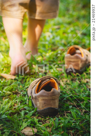 Child take off shoes and learns to walk on grass 21469937