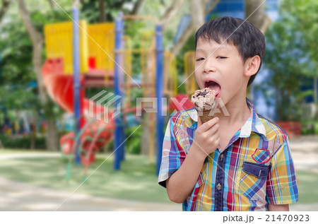 Young asian boy eating icecream at playground Young asian boy eating icecream at playground 21470923