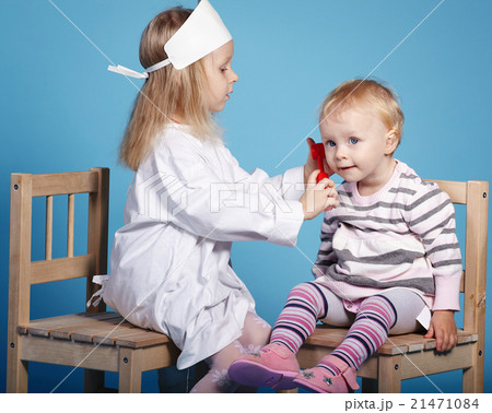 two cute little girls playing doctor 21471084