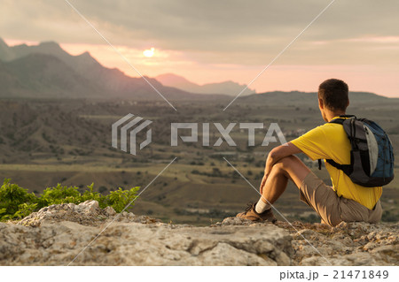 Hiker with backpack sitting on a rock 21471849