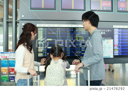 発着案内板の前で出発時間を見る家族 21476292