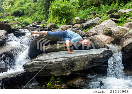 Woman doing yoga oudoors at tropical waterfall 21510948